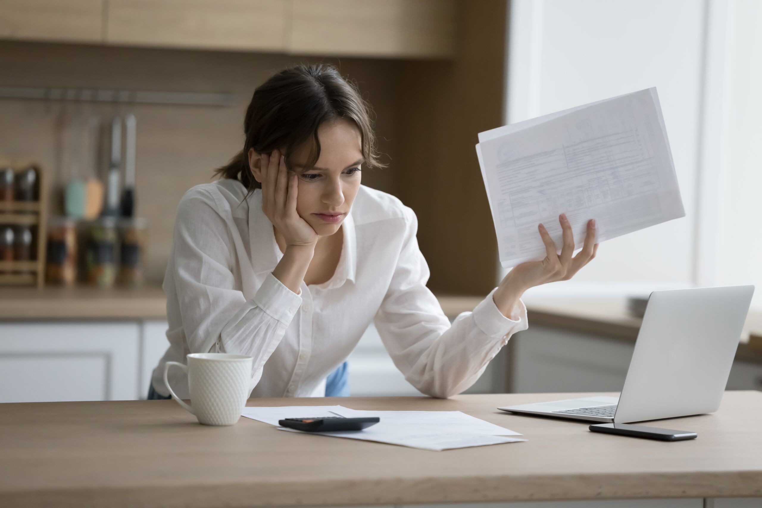 Blog-Stressed,Woman,Hold,Documents,,Read,Bad,Notice,,Feels,Shocked,Due Woman denied for mortgage staring at laptop frustrated