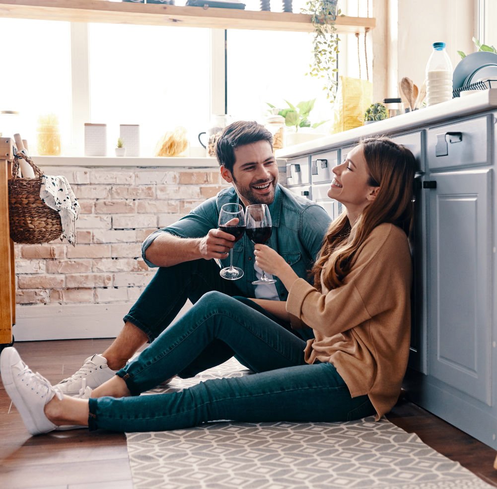 Two people laughing enjoying a glass of wine